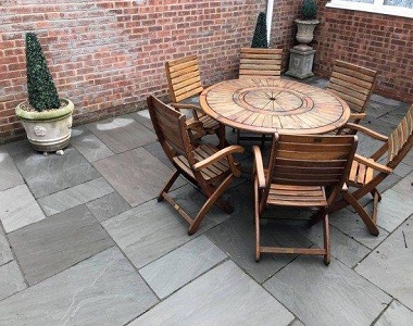 Grey sandstone pavers around an outdoor dining table.