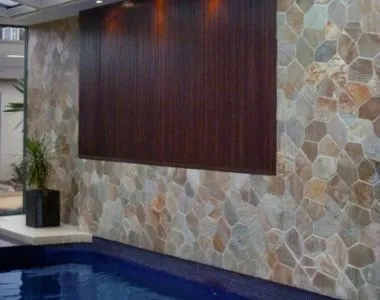 Golden quartz crazy paving wall tiles around a pool area