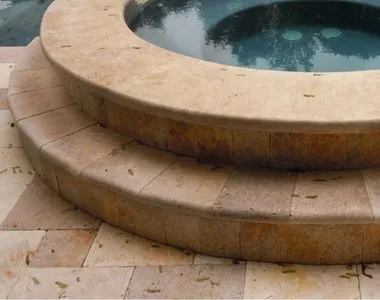 Noce Travertine bullnose pool copers used as steps around a pool.